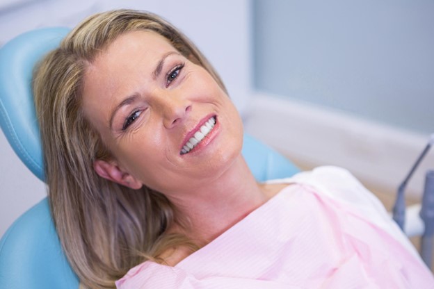 woman smiling in the dental chair before we use the Isolite dental isolation system
