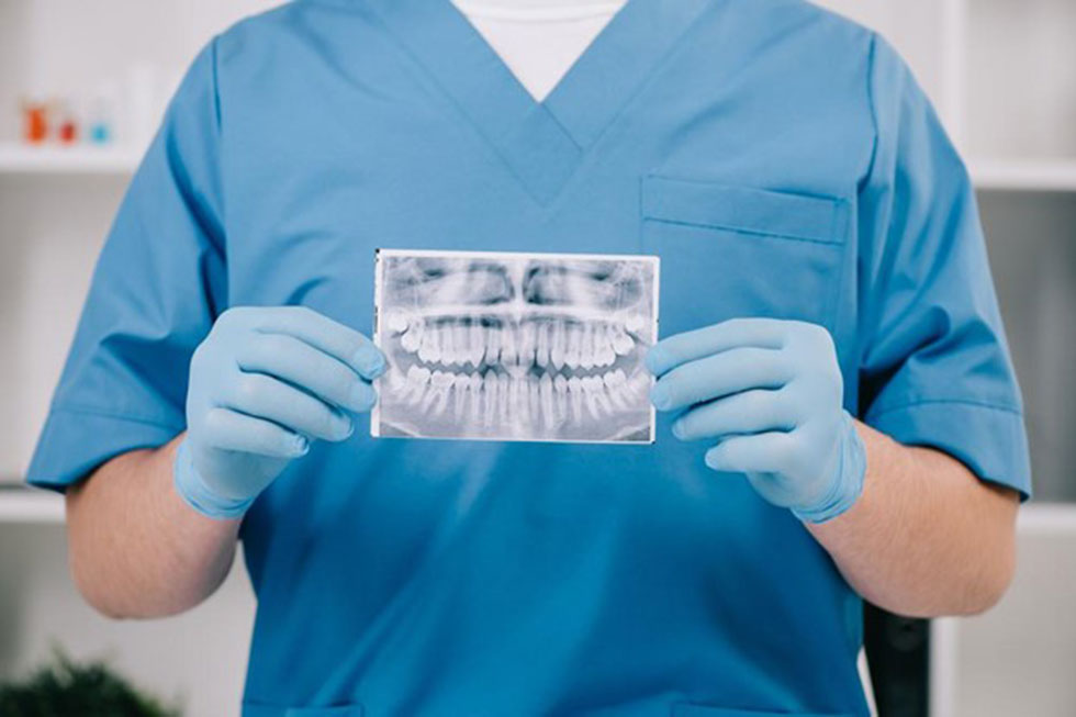 dental care professional holding a Planmeca CBCT x-ray image