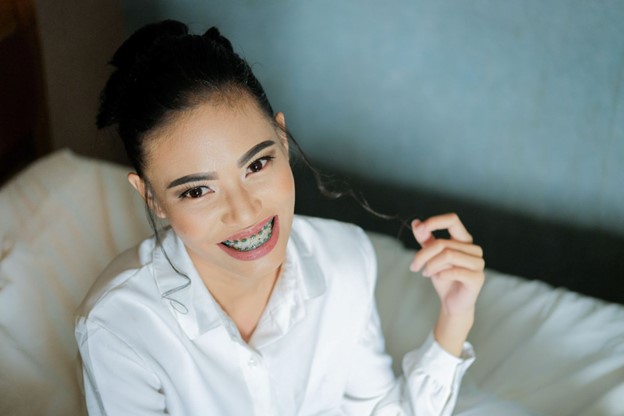 Young woman with braces smiles after visiting orthodontists and dentists in Oakbrook Terrace, IL